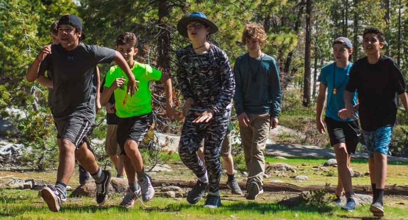 A group of people run across grass